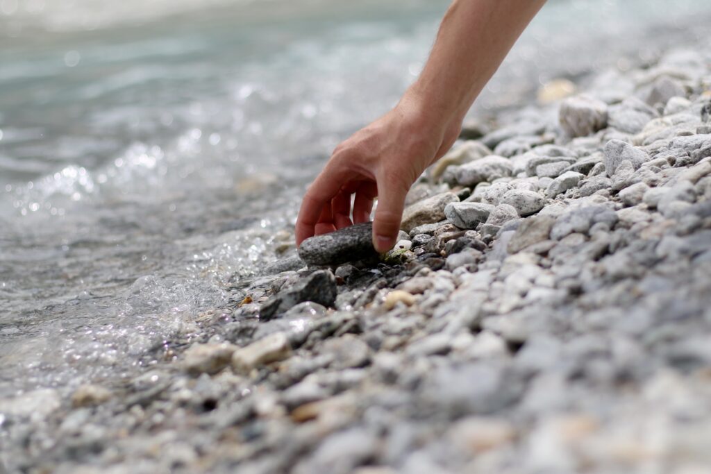 Picking up river rocks from side of water