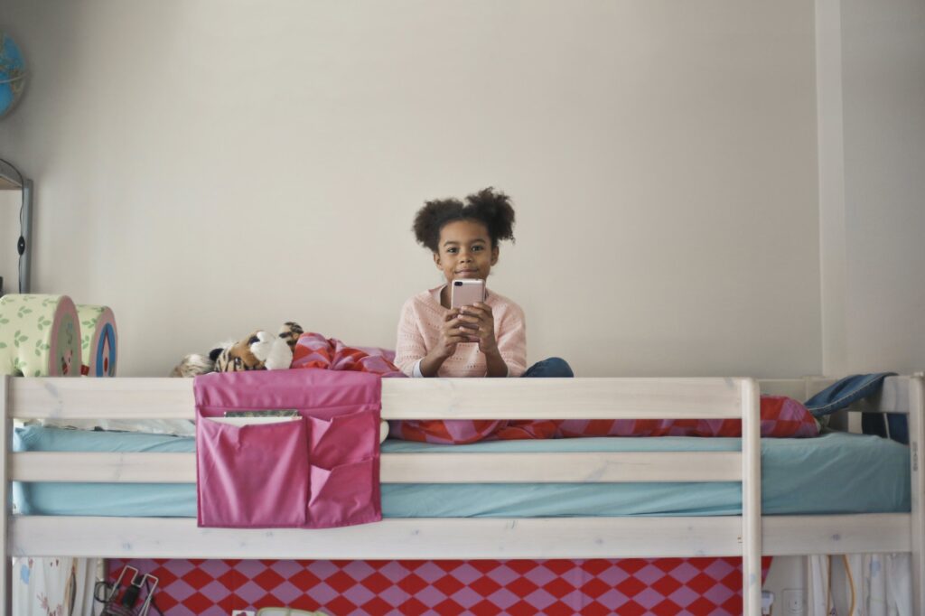 girl with phone on bunk bed
