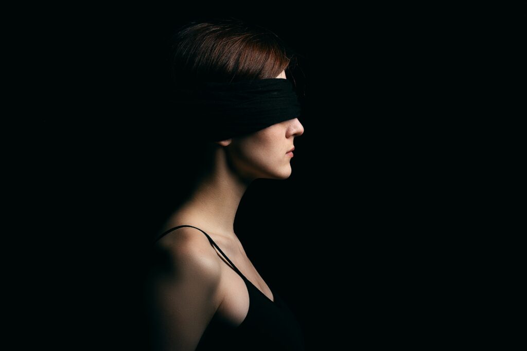 Blindfolded woman in front of a black background