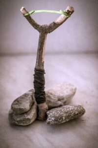 an upright stick sling shot propped up by rocks.